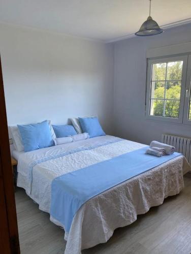 a bedroom with two beds with blue sheets and a window at Prado verde in Santa Comba