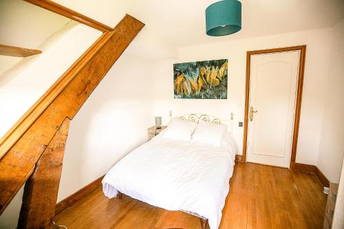 ein Schlafzimmer mit einem weißen Bett und einer Treppe in der Unterkunft Chambres d Hôte Bords de Seine Vernon-Giverny in Vernon