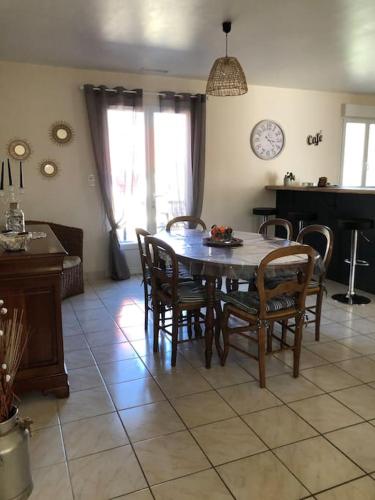a dining room with a table and chairs and a piano at Gîte “Les reflets de la Charente” in Condac