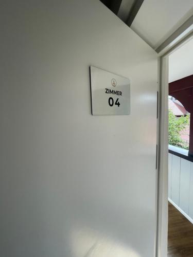 a sign on the side of a white wall at Hopfenhotel am Adenauerufer in Bamberg