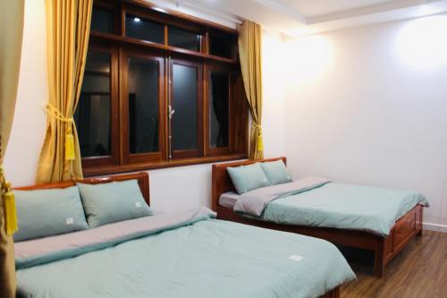 a room with two beds and a window at NHỚ House IV in Da Lat