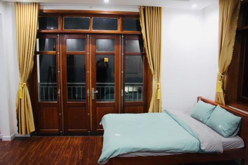 a bedroom with a bed and a wooden door at NHỚ House IV in Da Lat