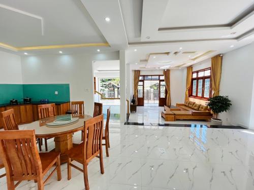 a dining room and living room with a table and chairs at NHỚ House IV in Da Lat