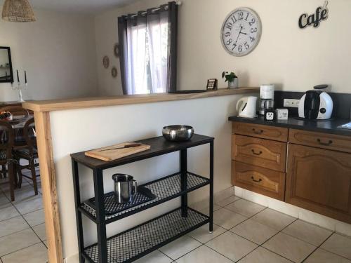 a kitchen with a table and a clock on the wall at Gîte “Les reflets de la Charente” in Condac