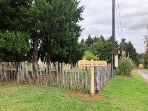 a wooden sign in front of a fence at Gîte “Les reflets de la Charente” in Condac