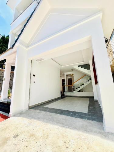 an empty house with white walls and a staircase at NHỚ House IV in Da Lat