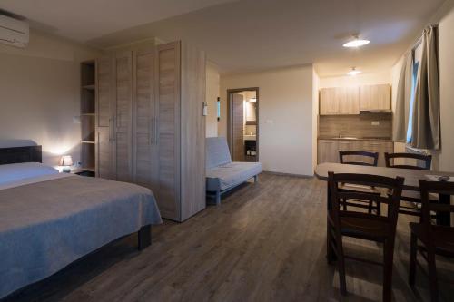 a bedroom with a bed and a table and a kitchen at Guest House Valentincic in Nova Gorica