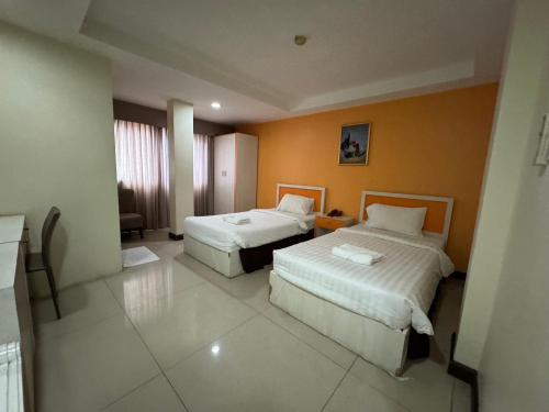 a hotel room with two beds in a room at Orchid Inn SKV3 in Bangkok