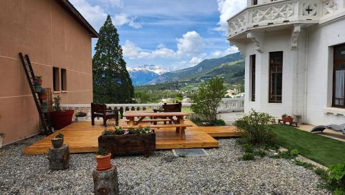 a patio with a wooden table and a bench at Résidence Château des Magnans by Nevesol in Jausiers