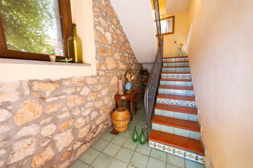 a staircase in a house with a stone wall at B&B Alfrantoio Valderice in Valderice