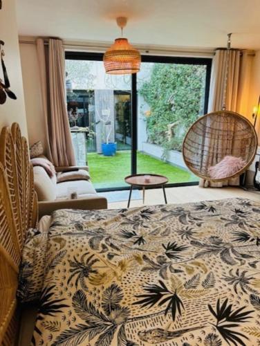 une chambre avec un lit, une chaise et une fenêtre dans l'établissement Maison -Jacuzzi -Patio -330M2, à Montrouge