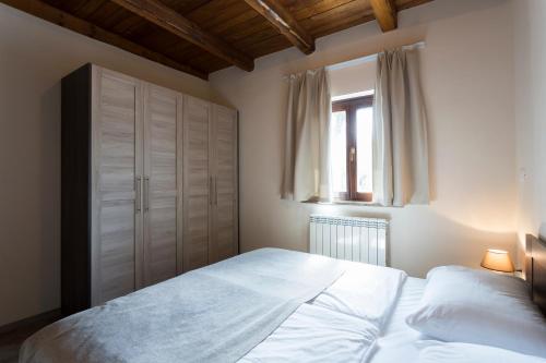Guest House Valentincic في نوفا جوريكا: غرفة نوم بسرير ابيض ونافذة