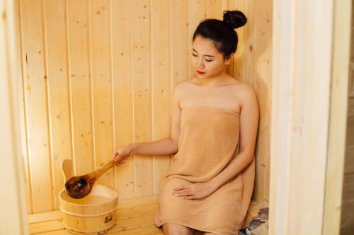 a woman standing in a room with a wooden spoon at Muong Thanh Luxury Phu Tho in Việt Trì