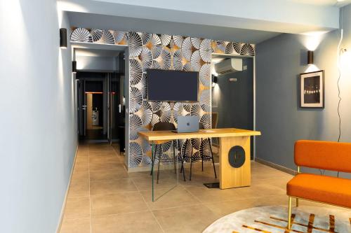 a room with a table and a tv on a wall at Palais Bernadette in Parma