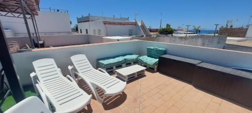 a patio with chairs and a bench on a roof at Casa totalmente nueva a 50 metros de la playa in El Palmar