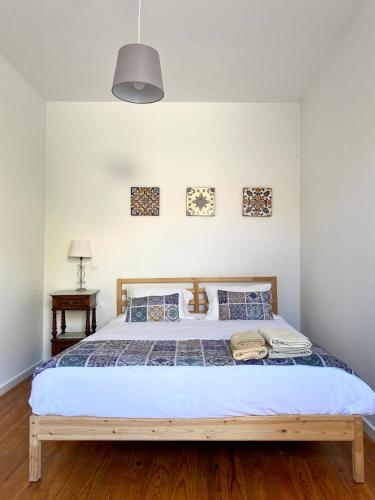 a bedroom with a large bed with a wooden frame at Casa Devesas in Vila Nova de Gaia