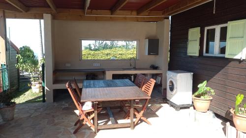einen Holztisch und Stühle auf einer Terrasse in der Unterkunft La case d'Isabelle in Saint-Denis