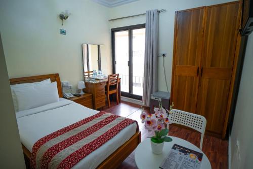 a bedroom with a bed and a table with flowers on it at Al Karnak Hotel in Dubai