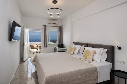 a bedroom with a bed with a view of the ocean at Villa Thiranthemis in Fira