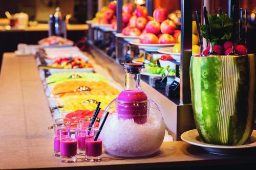 a buffet line with fruits and vegetables and drinks at Mövenpick Hotel Zürich-Regensdorf in Regensdorf
