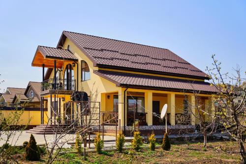 a yellow house with a brown roof at Villa Vermont Qusar in Qusar