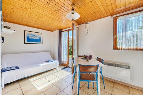 a bedroom with a bed and a table and chairs at Le Papillon - Maison proche côte normande in Valsemé