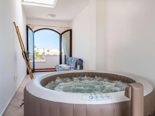 a large bath tub in a room with a window at Casa a Mare di Mamma Lucia - Idromassaggio - Fronte Mare in Torre San Gennaro