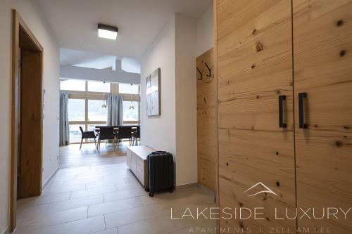 a room with a large wooden door with a suitcase at Lakeside Luxury Apartments in Zell am See