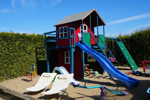a playground with a slide and some chairs at Gama Spa in Władysławowo