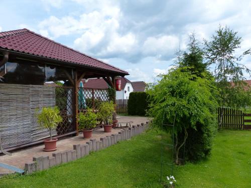 a garden with a gazebo with potted plants at Penzion Říše in Třeboň