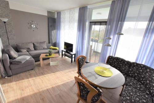 a living room with a couch and a table at FeWo Sunshine-Dahme in Dahme