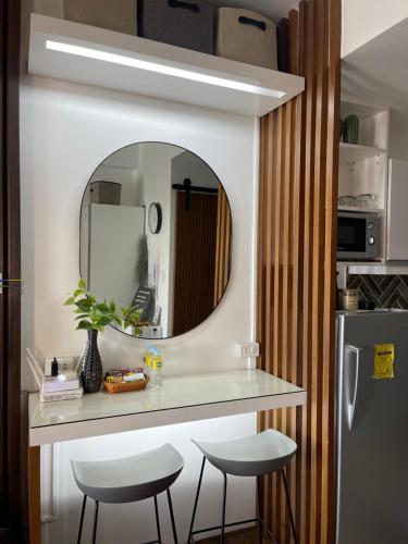 马尼拉Muji-Inspired hōme-tél in the heart of Makati的厨房配有带2张凳子和镜子的台面