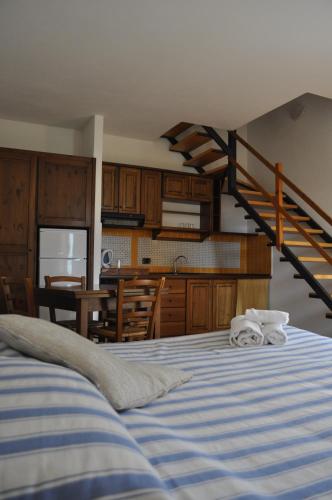 een slaapkamer met een bed, een keuken en een trap bij Borgo San Francesco in Gioiosa Marea