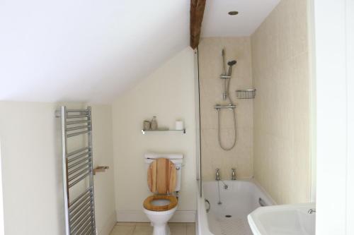 a bathroom with a toilet and a bath tub at Clayhanger Lodge in Abbotsbury