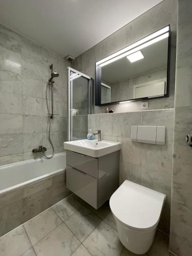 a bathroom with a sink and a toilet and a tub at Ferienwohnung FAIRWAY in Hohenkirchen