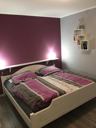 a bedroom with a bed with purple walls at Ferienwohnung FAIRWAY in Hohenkirchen