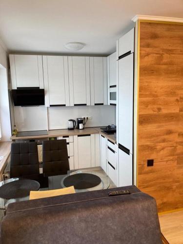 a kitchen with white cabinets and a table and chairs at Liela Studio Liela Street in Liepāja
