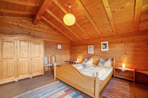 1 dormitorio con 1 cama en una cabaña de madera en Ferienhaus Rauchegg - Bergblick, en San Pancrazio