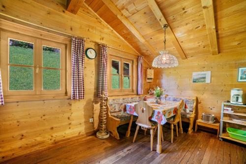 a dining room in a log cabin with a table and chairs at Ferienhaus Rauchegg - Bergblick in San Pancrazio dʼUltimo