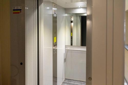 a glass door in a bathroom with a mirror at Palais Bernadette in Parma