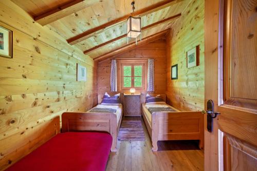 a room with two beds in a log cabin at Ferienhaus Rauchegg - Bergblick in San Pancrazio dʼUltimo