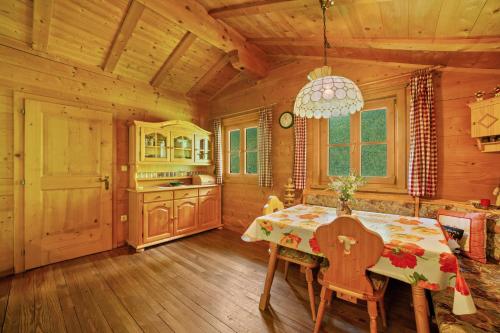 a dining room with a table and a kitchen at Ferienhaus Rauchegg - Bergblick in San Pancrazio dʼUltimo