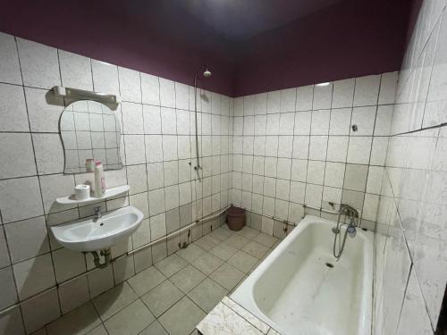 La salle de bains est pourvue d'un lavabo et d'une baignoire. dans l'établissement Couba Club, à Douala