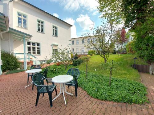 a group of tables and chairs on a brick patio at Haus Lucie 50m bis zum Ostseestrand in Heringsdorf
