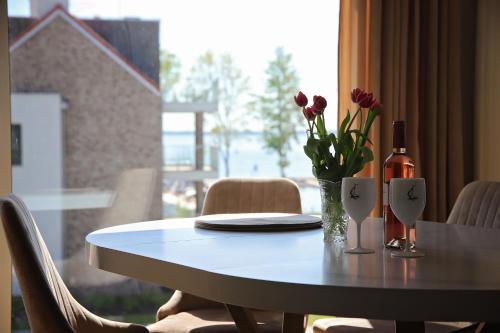 uma mesa com uma garrafa de vinho e flores em Apartament Take Your Time em Giżycko