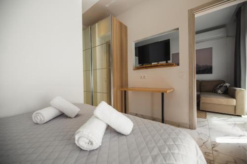 a bedroom with two towels on a bed with a television at Luxury apartment in the center of Ioannina city in Ioannina