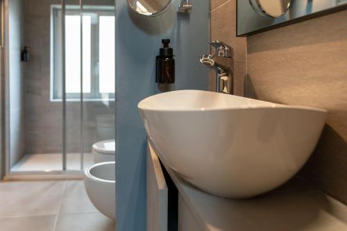 a bathroom with a white sink and a toilet at Palais Bernadette in Parma