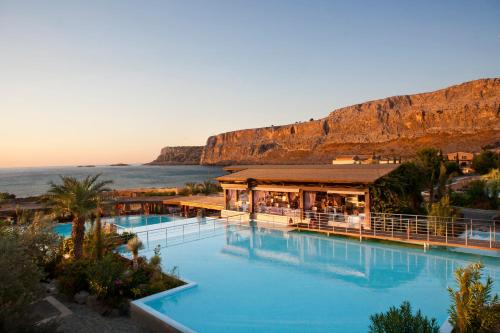 un complejo con una gran piscina junto al océano en Aquagrand Exclusive Deluxe Resort Lindos - Adults only en Lindos