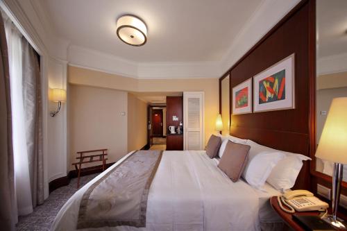 a bedroom with a large bed with a phone on it at Hotel Royal Macau in Macau