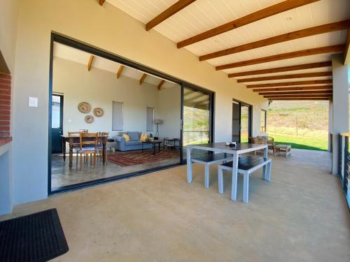 uma sala de jantar e sala de estar com portas de vidro deslizantes em Sneeukop Mountain Cottage em Paarl